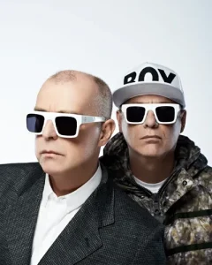 Neil Tennant & Chris Lowe portant tous deux des lunettes de soleil noir et blanc sur fond blanc, Chris portant une casquette "BOY".